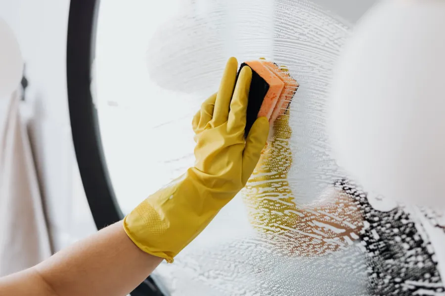 A person cleaning a mirror