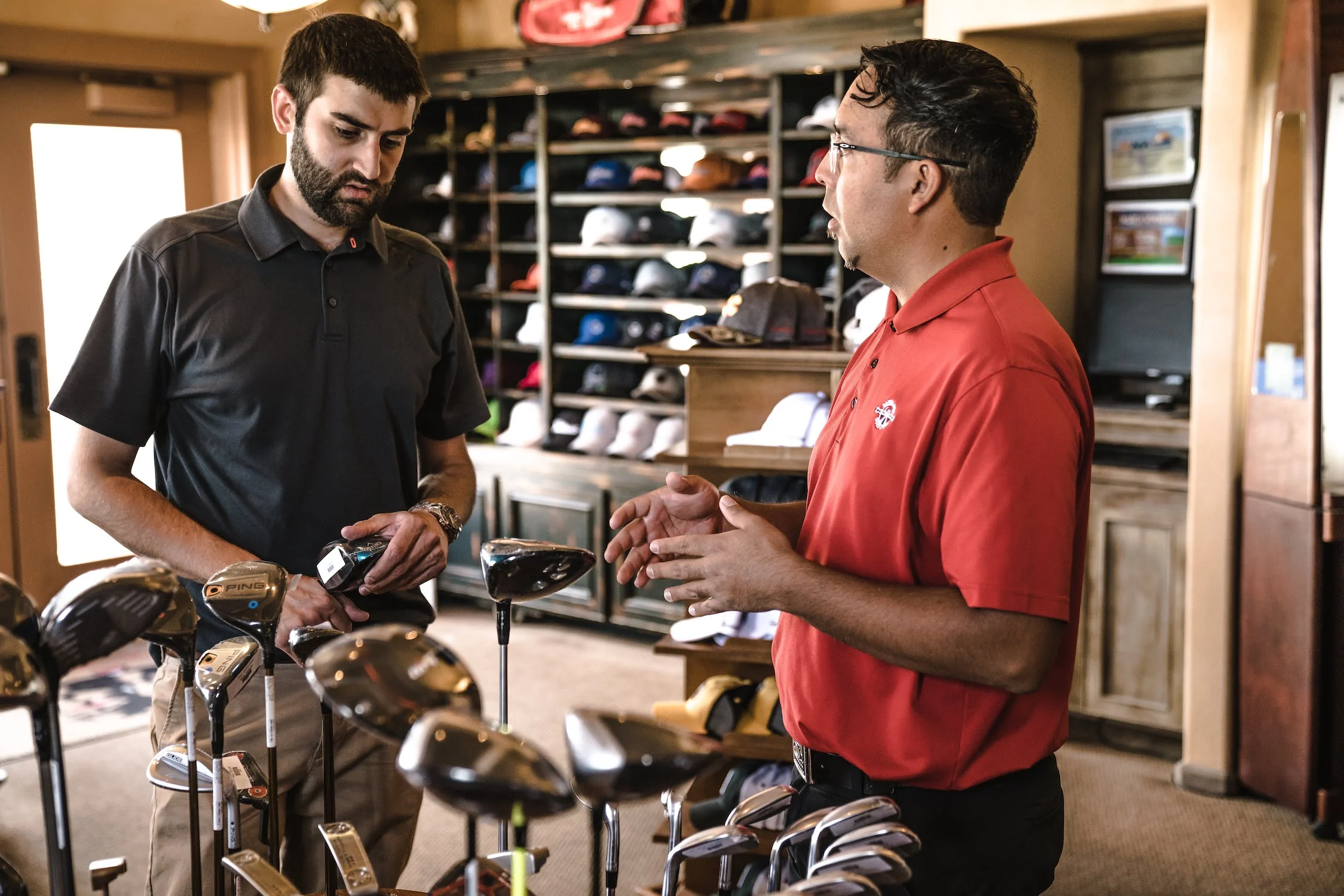 A salesman selling golf kit to a customer